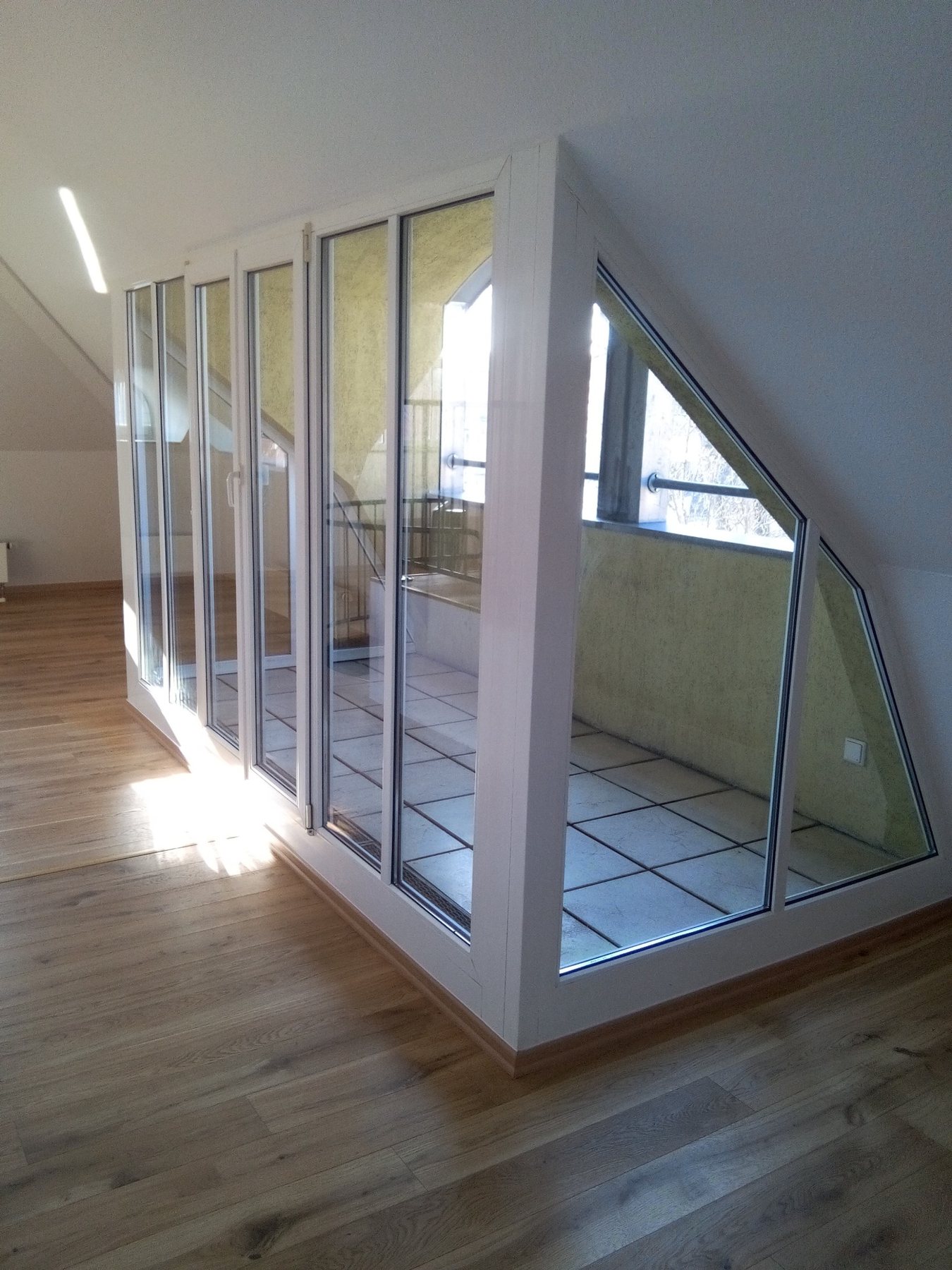 Referenz eines Bodenbelags in Holzoptik im Dachgeschoss mit Glasfront