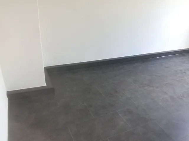 Dunkler Bodenbelag mit passendem Sockel- und Randabschluss